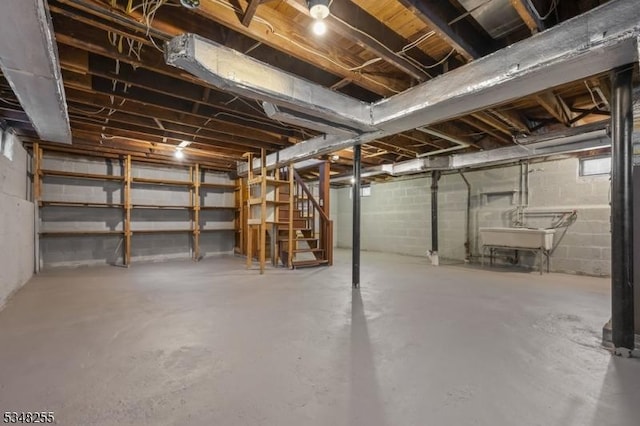 unfinished basement with a sink and stairway
