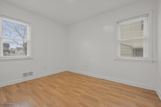 empty room featuring light wood-style flooring and baseboards