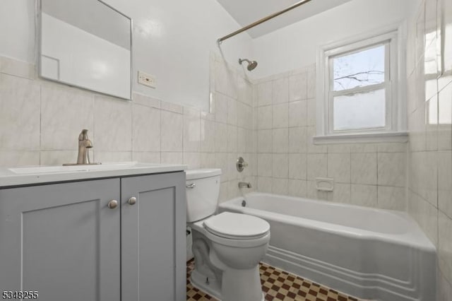 full bath with tile walls, toilet, tile patterned floors,  shower combination, and vanity