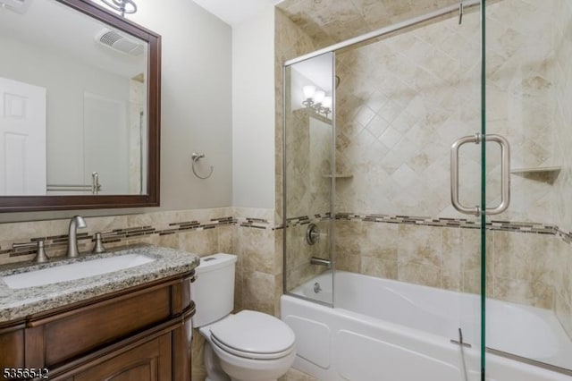 66 Jamestown Rd, Bernards Twp, NJ 07920 - bathroom featuring toilet, vanity, shower / bath combination with glass door, tile walls, and wainscoting