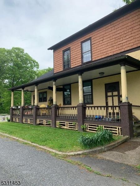 917 Main St, Stillwater Twp, NJ 07860 - view of property exterior featuring covered porch, stucco siding, and roof with shingles