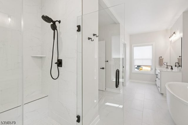 bathroom featuring a marble finish shower, vanity, marble look tiles, and a freestanding tub