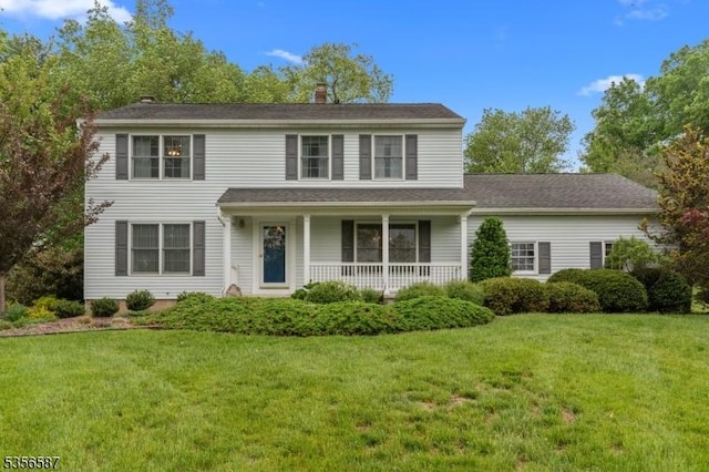 traditional-style house with a porch, a front lawn, and a chimney
