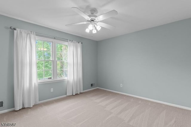 unfurnished room featuring light carpet, ceiling fan, and baseboards