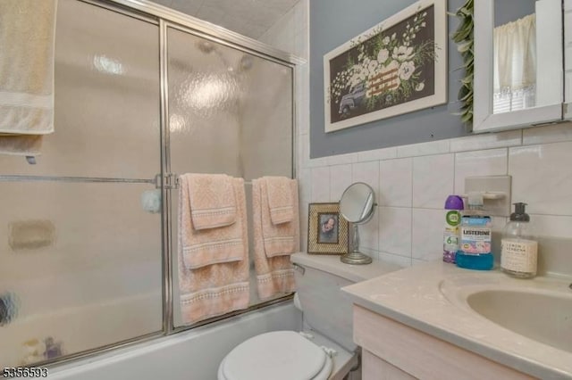 127 Brill St, Newark City, NJ 07105 - full bathroom featuring combined bath / shower with glass door, vanity, toilet, tile walls, and backsplash