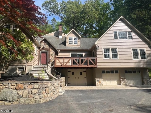 204 Musconetcong River Rd, Lebanon Twp, NJ 07882 - view of front of house featuring stone siding, a garage, a chimney, and driveway