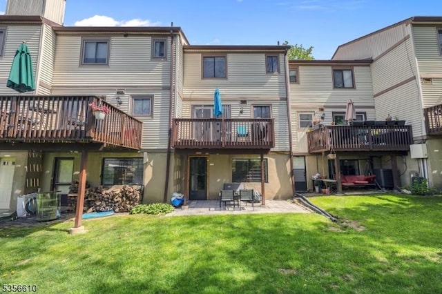 rear view of property featuring a lawn, a patio, a deck, and ac unit
