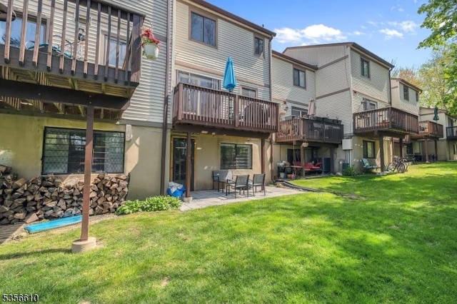 back of property with a yard, a patio, stucco siding, and a deck