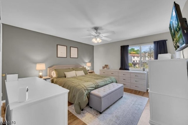 bedroom with light wood-style floors and a ceiling fan