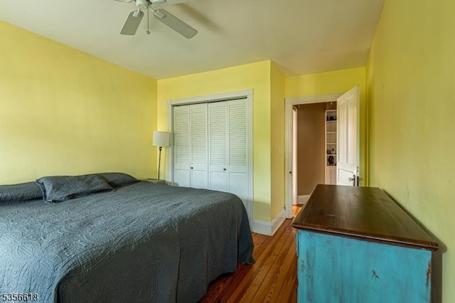 bedroom with dark wood-type flooring, a closet, baseboards, and a ceiling fan