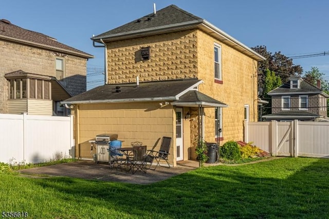 rear view of house featuring a shingled roof and a patio area