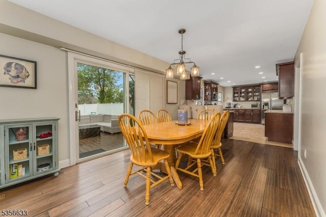 dining area featuring wood finished floors, recessed lighting, baseboards, and a chandelier
