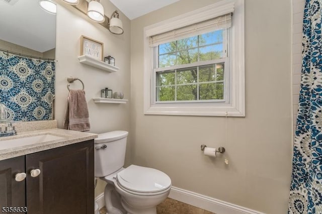 bathroom featuring toilet, vanity, a shower with shower curtain, and baseboards