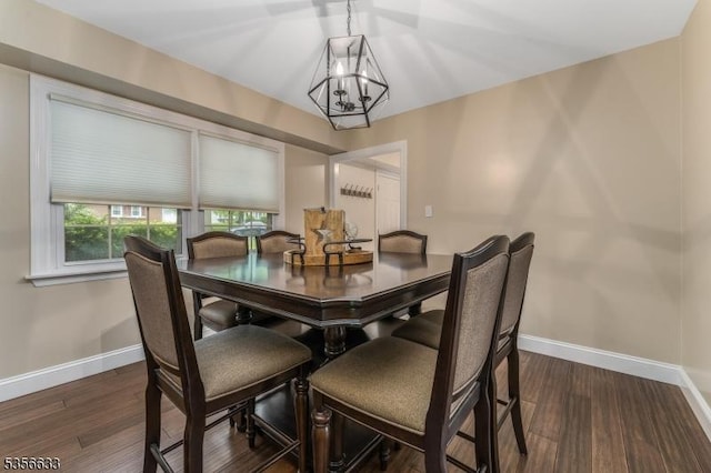dining room featuring a chandelier, baseboards, and dark wood-style flooring