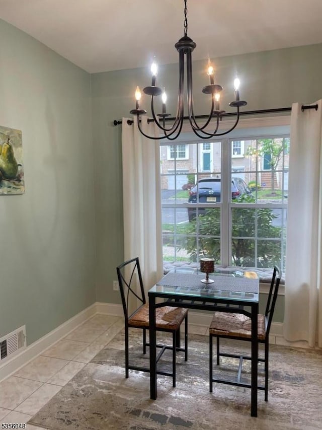dining space featuring a chandelier and baseboards
