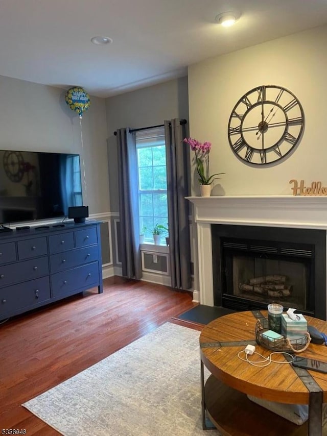 living room featuring wood finished floors, a fireplace, and recessed lighting