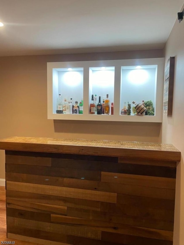 indoor dry bar featuring wood finished floors