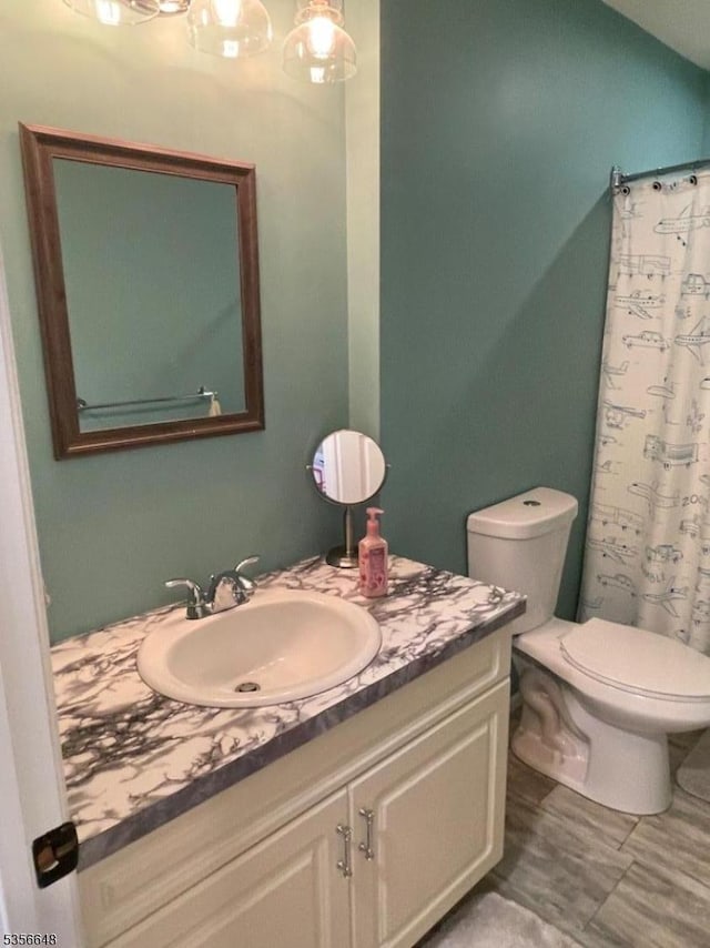 bathroom featuring vanity, toilet, and a shower with shower curtain