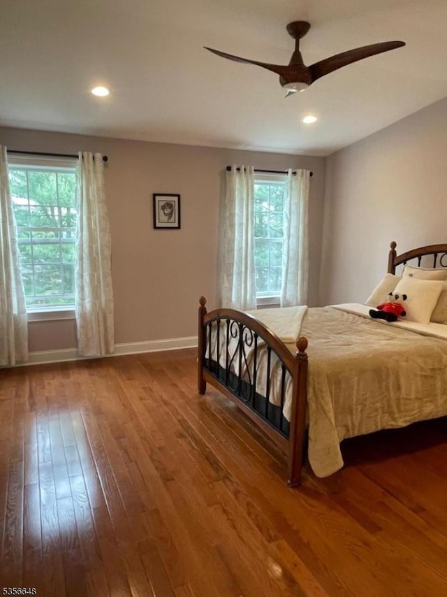 bedroom with multiple windows, hardwood / wood-style flooring, baseboards, a ceiling fan, and recessed lighting
