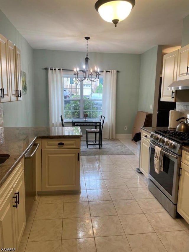 kitchen featuring appliances with stainless steel finishes, under cabinet range hood, tasteful backsplash, a chandelier, and light tile patterned flooring