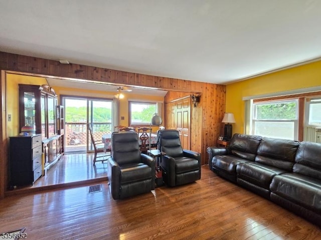 living area with wooden walls and hardwood / wood-style floors