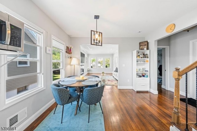 dining room with wood finished floors, baseboards, stairs, and a chandelier
