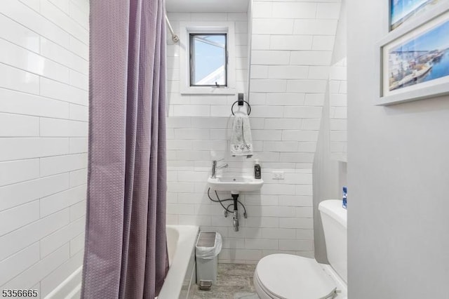 full bath featuring toilet, shower / bath combination with curtain, tile walls, and a sink