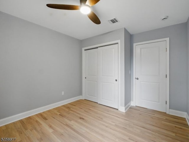 unfurnished bedroom with light wood finished floors, baseboards, a closet, and a ceiling fan