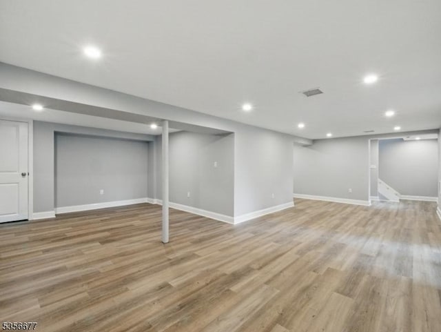 finished below grade area featuring recessed lighting, light wood finished floors, and baseboards