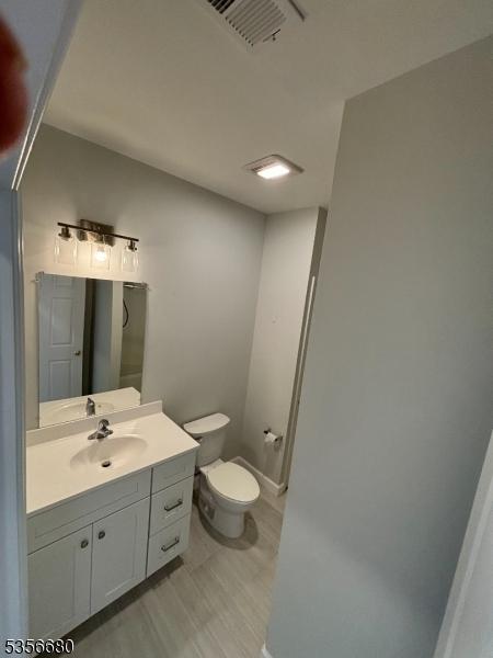 758 Somerset St Unit 2, Watchung Boro, NJ 07069 - bathroom with toilet, wood finished floors, vanity, and baseboards