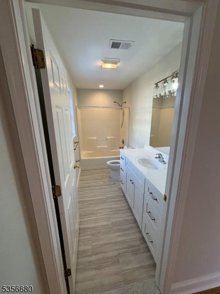 758 Somerset St Unit 2, Watchung Boro, NJ 07069 - full bathroom with toilet, bathtub / shower combination, vanity, wood finished floors, and baseboards