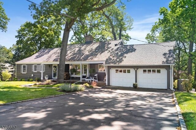 66 Skyline Dr, Morris Twp, NJ 07960 - view of front of house with a chimney, a garage, asphalt driveway, a front yard, and cooling unit