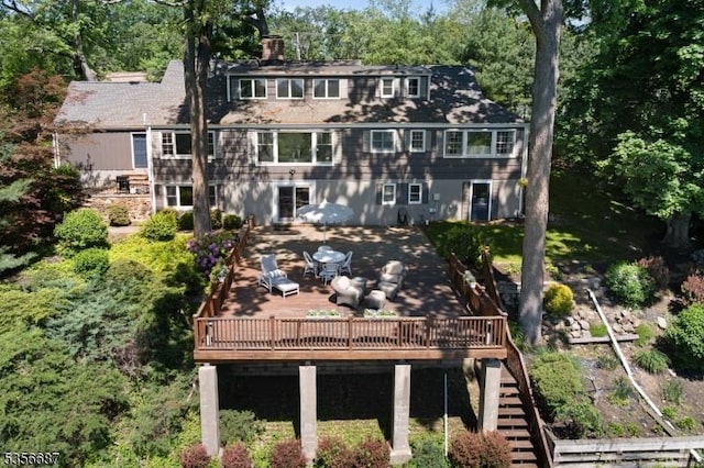 66 Skyline Dr, Morris Twp, NJ 07960 - rear view of property featuring stairs, a deck, a chimney, and outdoor dining area