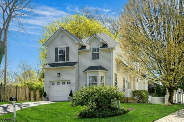 traditional-style home with driveway, an attached garage, and a shingled roof