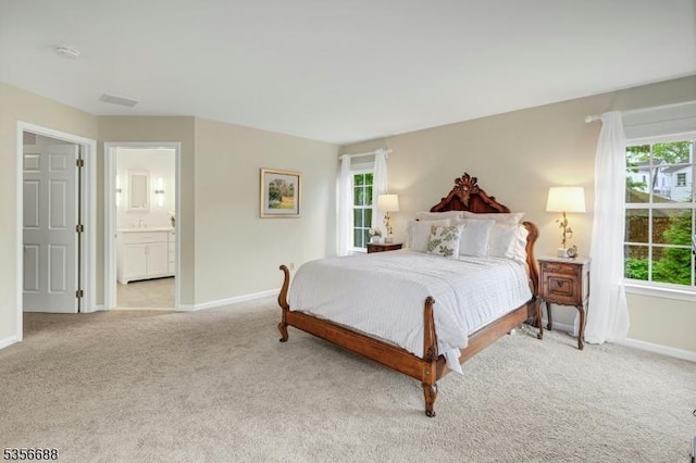 bedroom with multiple windows, light carpet, and baseboards