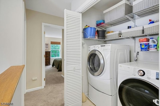 laundry area featuring separate washer and dryer, light colored carpet, and baseboards