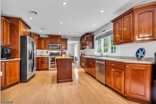 23 Andover Dr, Branchburg Twp, NJ 08853 - kitchen featuring appliances with stainless steel finishes, light wood finished floors, light countertops, a center island, and a sink