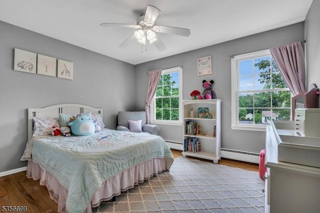 23 Andover Dr, Branchburg Twp, NJ 08853 - bedroom featuring a baseboard heating unit, multiple windows, and wood finished floors