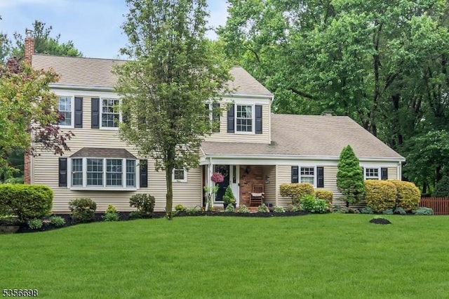 23 Andover Dr, Branchburg Twp, NJ 08853 - view of front of house with a front yard, a chimney, and a porch