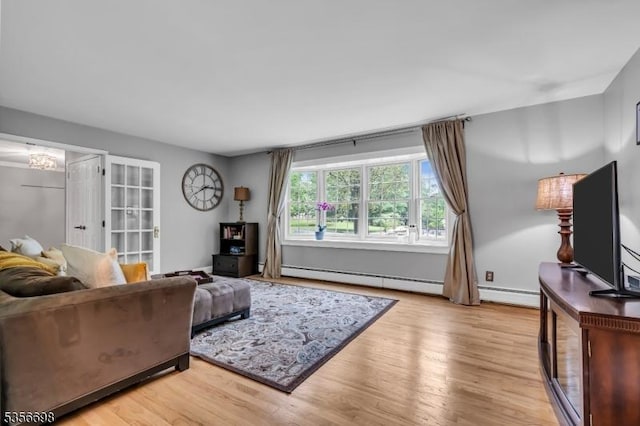 23 Andover Dr, Branchburg Twp, NJ 08853 - living area with a baseboard heating unit, light wood finished floors, and a chandelier
