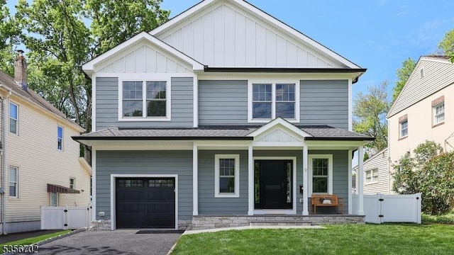 view of front of property featuring board and batten siding, an attached garage, a porch, and a gate