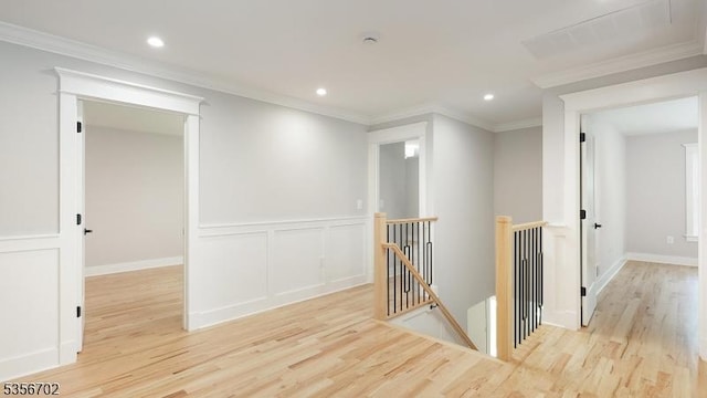 hall with an upstairs landing, wood finished floors, recessed lighting, and crown molding