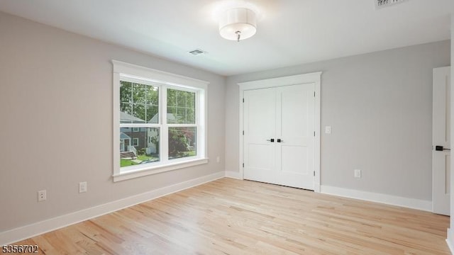 unfurnished bedroom with light wood finished floors and baseboards