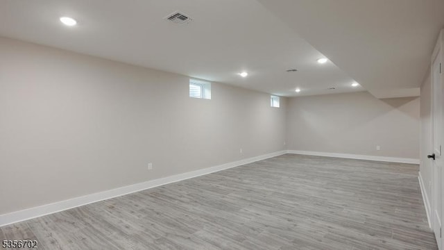 below grade area with recessed lighting, baseboards, and light wood-type flooring