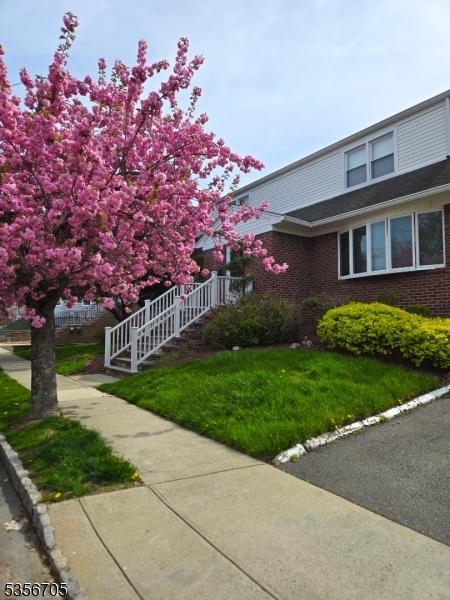 50 Newark Pl, Belleville Twp, NJ 07109 - view of side of property with a lawn, brick siding, and stairway
