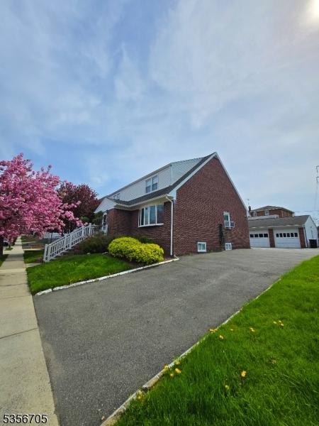 50 Newark Pl, Belleville Twp, NJ 07109 - view of property exterior featuring brick siding, a detached garage, and a yard