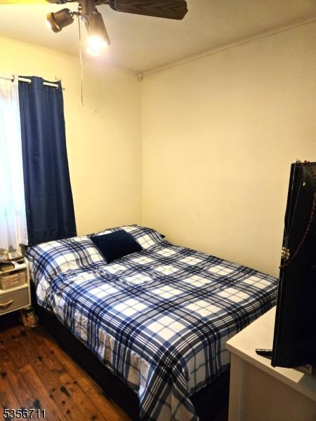 bedroom featuring wood finished floors, ceiling fan, and ornamental molding