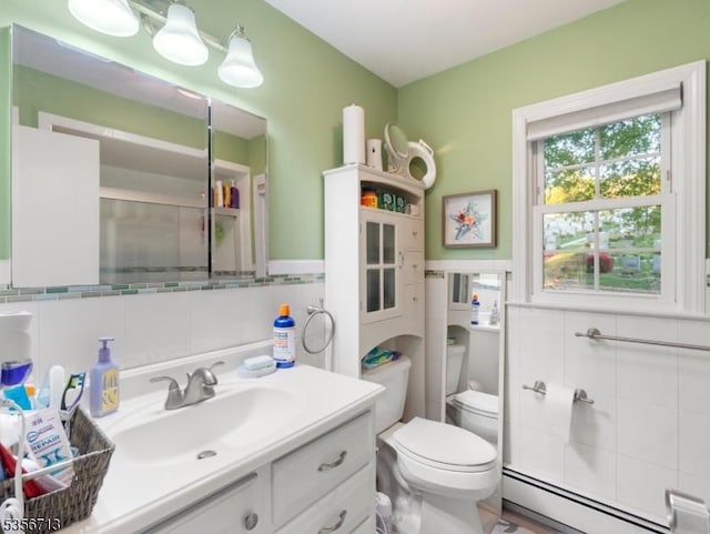 full bathroom featuring baseboard heating, tile walls, toilet, vanity, and a shower with door