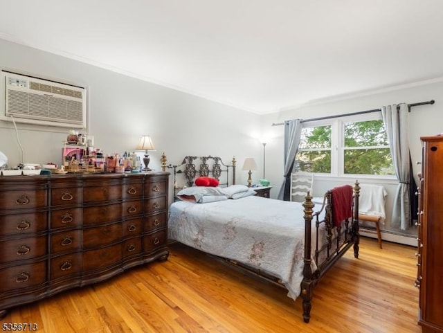 bedroom with a baseboard heating unit, light wood-style flooring, an AC wall unit, and ornamental molding