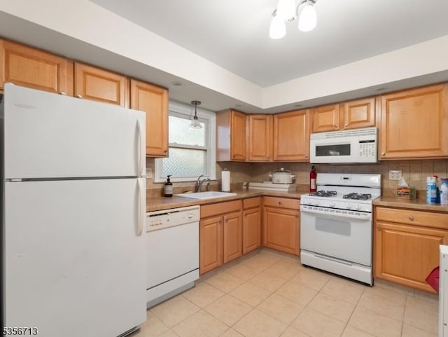 kitchen with white appliances, a sink, decorative backsplash, light countertops, and light tile patterned flooring